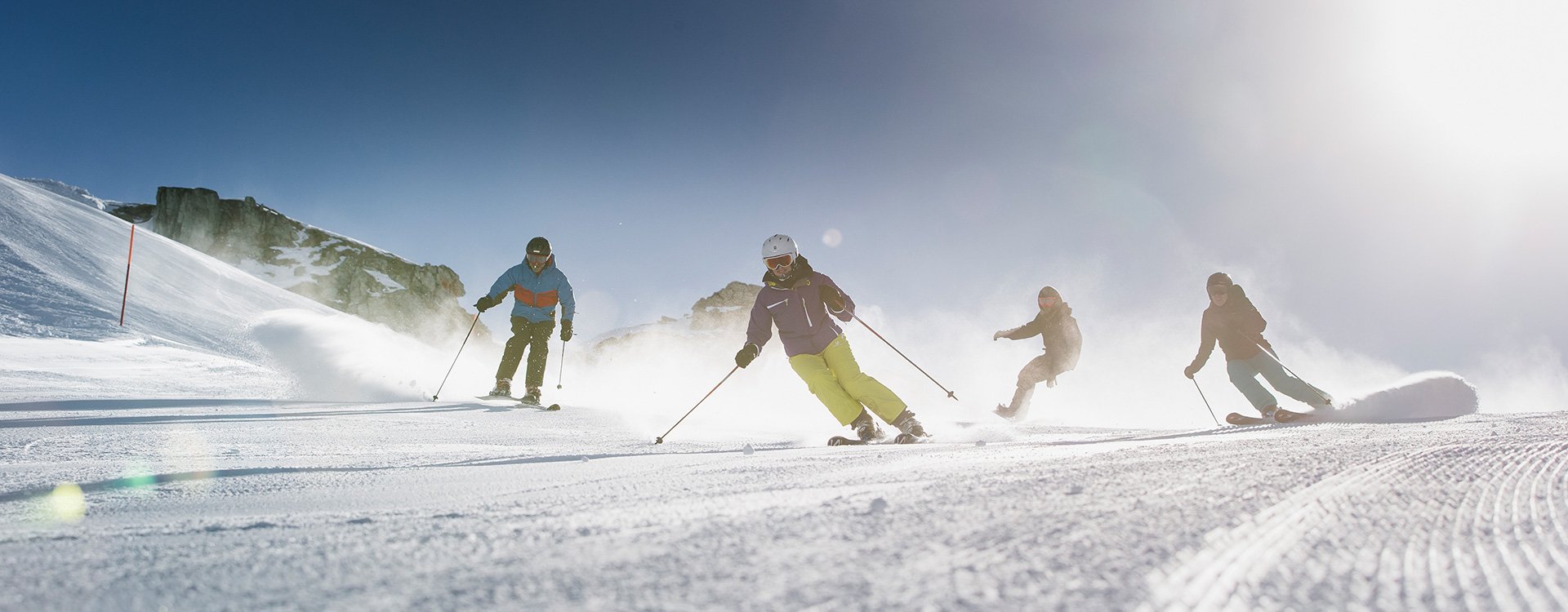 Eine Gruppe Erwachsener am Skie und Snowboard fahren.