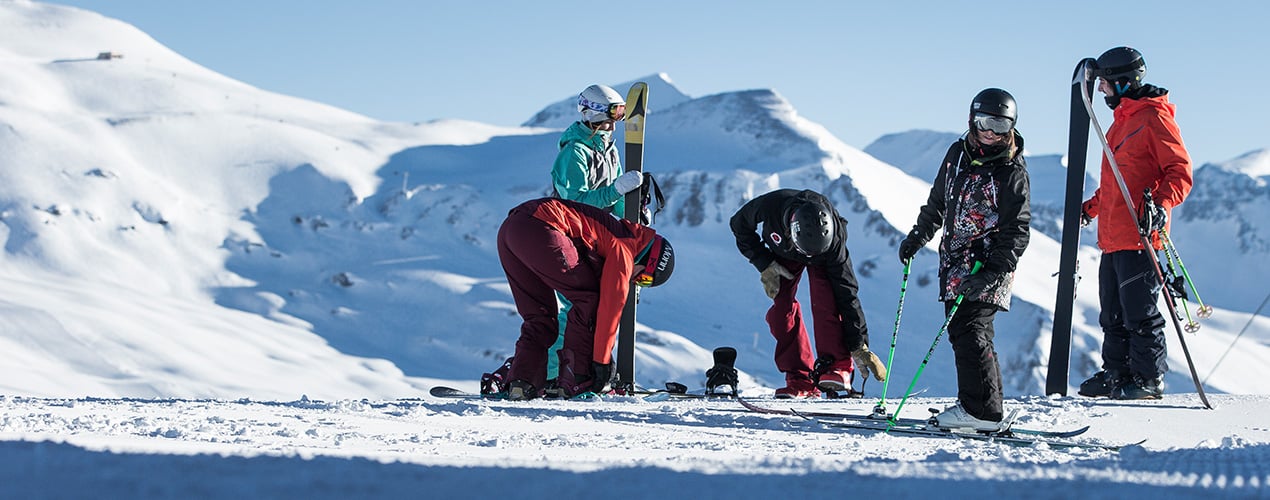 Eine Gruppe von fünf Personen sind sich am vorbereiten zum Ski und Snowboard fahren.