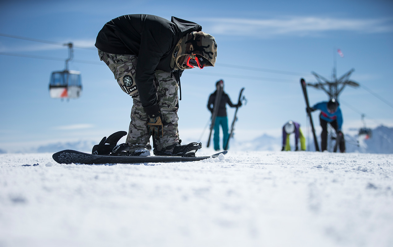 Snowboarder zieht die Bindung an.